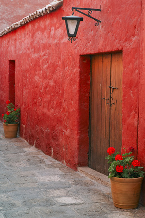 Old wooden door on an red wall at Arequipa, Peruの写真素材