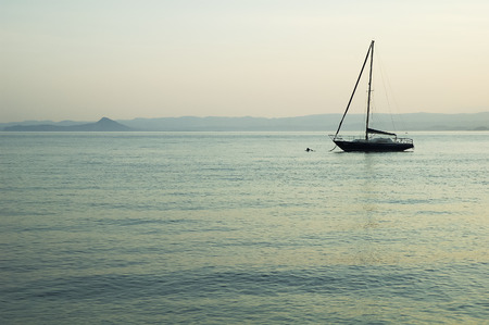 Single boat on the lake at sunsetの写真素材
