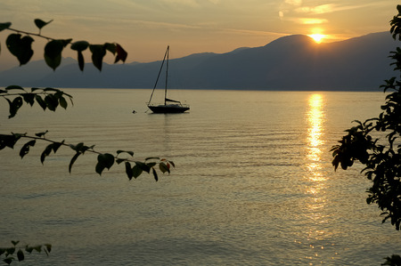 Single boat on the lake at sunsetの写真素材
