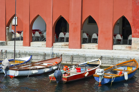 Three colorful boats at lake bank, Torbole, Italyの写真素材