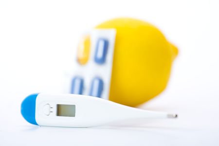 Thermometer, lemons and pills representing illness over white. Shallow dof.の写真素材