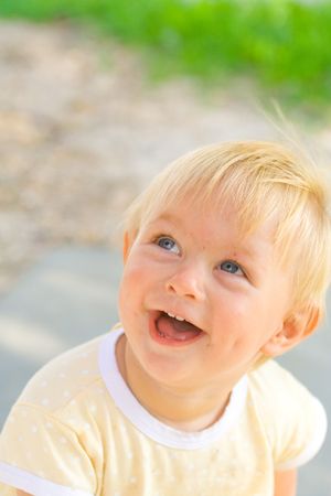 Smiling baby girl looking up, one year old.の写真素材