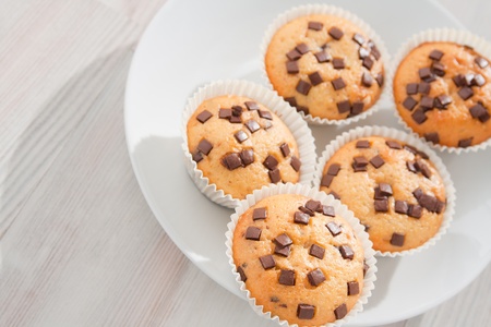 Many fresh and tasty home baked chocolate muffins on plate. の写真素材