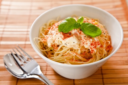 Spaghetti with vegetables, feta cheese and basil.の写真素材