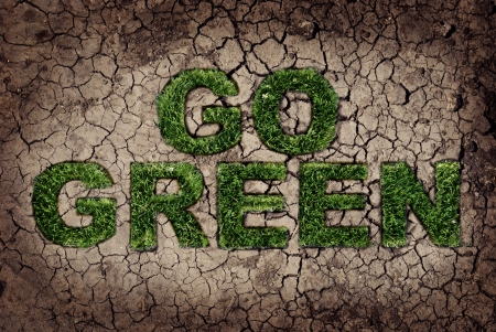 Eco concept. Grass growing from dry soil in Go Green shape.の写真素材