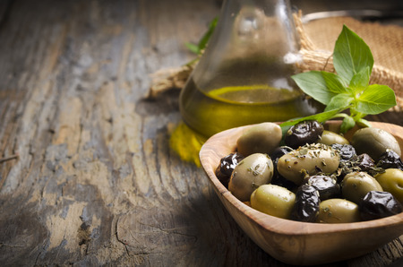 Olives and olive oil on rustic wooden tableの写真素材
