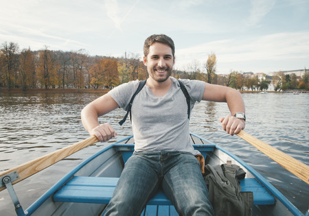 happy smiling man rowing on the riverの写真素材
