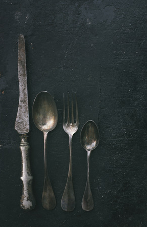 Vintage silverware on black rustic background. Retro filter.の写真素材