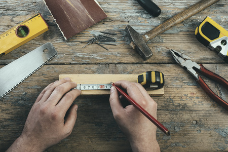 Male hands working on carpenter's desk and working tools.の写真素材