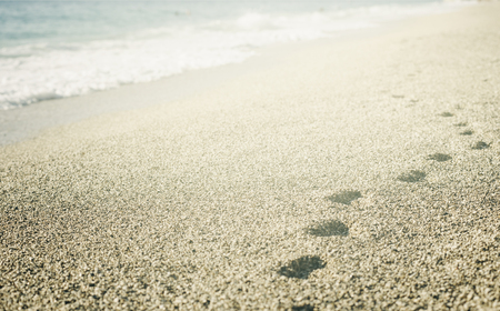 Footprints in the sand on the beach.