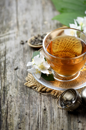 Jasmine and green tea in tea cup on wooden table.の写真素材