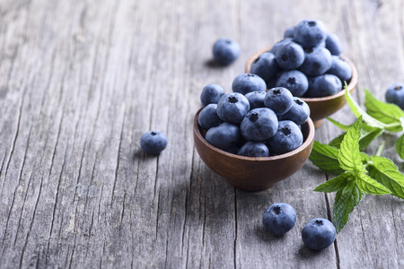 Bowl of fresh blueberries on rustic wooden table. Healthy organic seasonal fruit background. Organic...