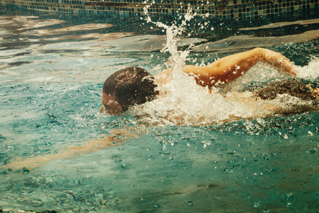 Young man swimmer train swimming in swimming pool. Recreation outdoor water sport. Vintage and retro...