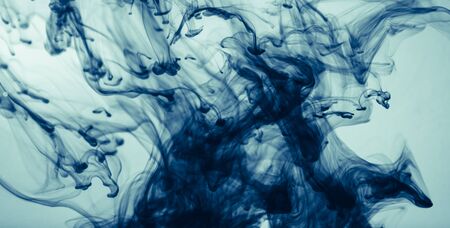 Abstract color paint splash on blue background. Modern design with motion liquid dye. Dark ink in water. の写真素材