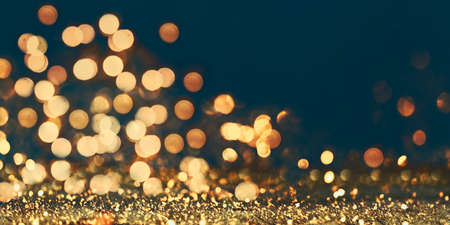 Abstract blur golden glitter border on black background. Luxury card design for new year, christmas and holiday celebration. Party bokeh sparkle confetti textured layout. Classy elegant banner.の写真素材