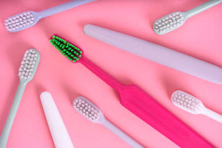 Different pastel tooth brushes pattern on color background. Many toothbrush choices for dental care...