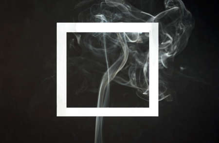 Empty photo frame with smoke on black background. Dark surreal concept with picture frame layout. Trendy minimal template with space for text.の写真素材