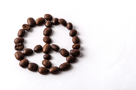 Coffee beans arranged as a peace sign isolated on white background with copyspaceの写真素材