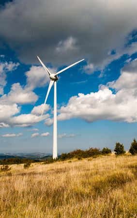 Single wind turbine in cloudy sky