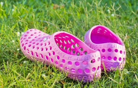 Pair of well worn sandals left on a well manicured, green grass lawn