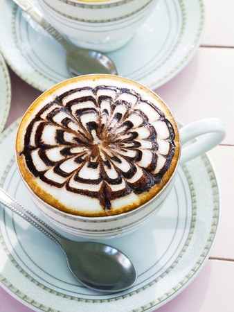 cappuccino coffee in white cup on wooden backgroundの写真素材
