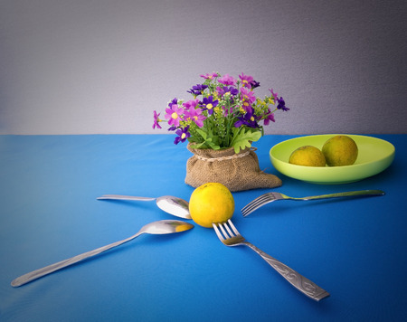 domestic orange on blue table with spoon and forkの写真素材