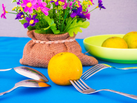 demestic orange on blue table  with spoon and forkの写真素材