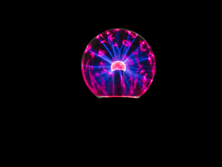 electric spark on plasma ball , the high voltage supply to inner electrode then electrons discharge through low pressure gas to outer sphereの写真素材