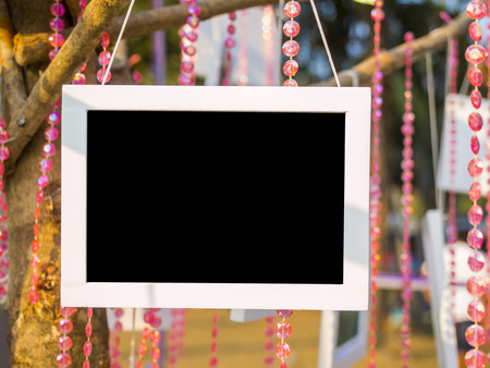 photo frame made of white wood, hanging on stick branch, outdoor galloryの写真素材