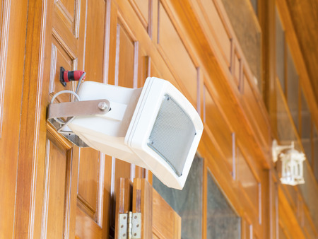 white loudspeaker installed on vertical wooden wall