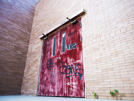 aged red door on brick wall backgroundのeditorial素材