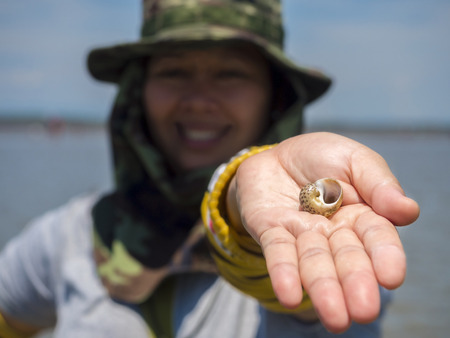 clam shell on woman's hand in the outdoor location