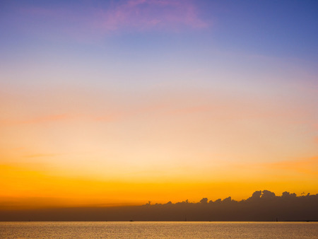 nature background, ripples on the sea and bright sun set over horizontal skyの写真素材