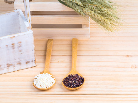 two types of milled rice on wooden spoons on tableの写真素材