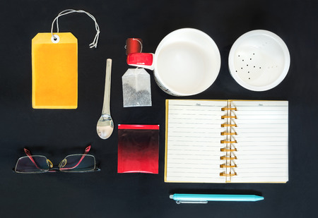 tea set with notebook , pen and glasses mockup on black backgroundの写真素材