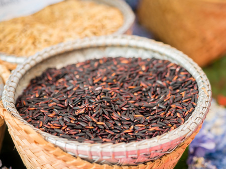 selective focus on raw rice grains on wooden bowlの写真素材