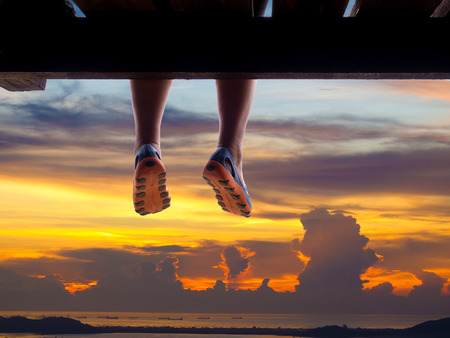 silhouette of woman's legs on the tropical sea with colorful sunrise on the skyの写真素材
