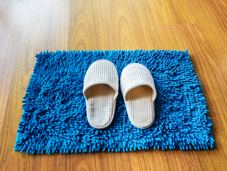 white clothing fluffy slippers on carpet and floorの写真素材
