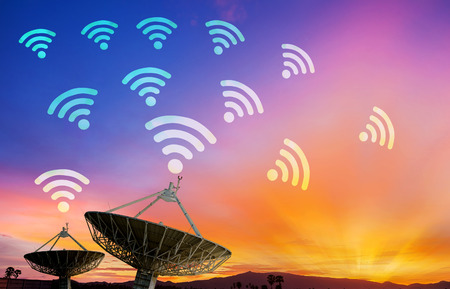 Satellite dish receiving data signal for communication, on colorful sunset skyの写真素材