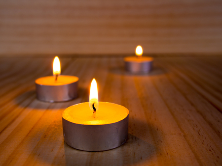 burning candle in meditation placed on wooden floorの写真素材