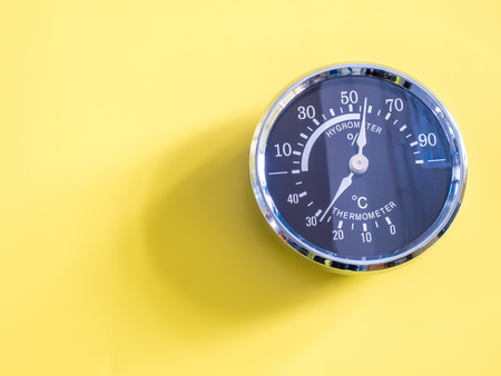 vintage Circle thermometer, measure temperature and humidity of climate on yellow background