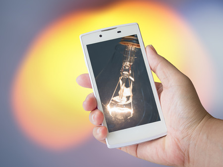 Human hand holding blank mobile smart phone on blur backgroundの写真素材