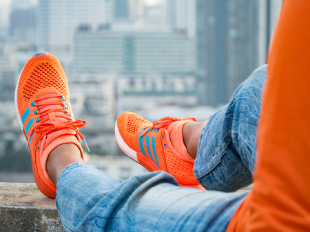 colorful sport shoes on woman feet on the roof of building