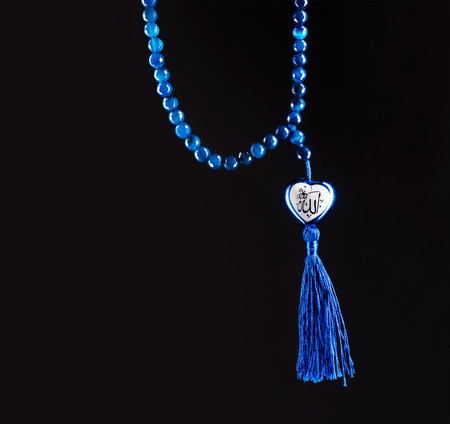 rosary beads on black, muslim bead with the word "Allah" the God name write on heart shapeの写真素材