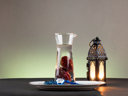 Date palm fruit drink "nabis", and Rosary with name of Muslim God "Allah" , and lightened Lantern by candleの写真素材