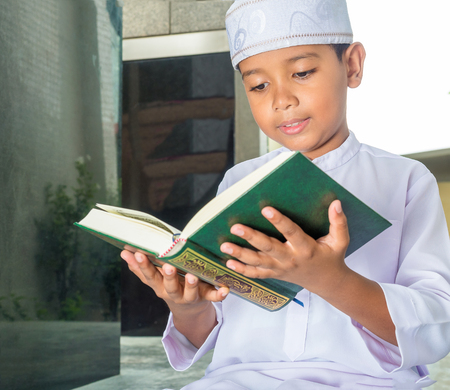 Asian muslim child with smile face reads the holy Quran(the public item of all muslims ).の写真素材