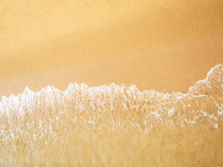 soft foam of wave reaching on the sea shore on beautiful sandの写真素材