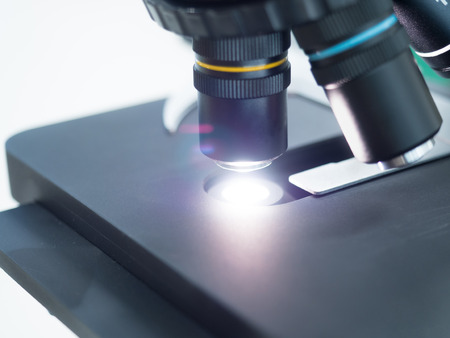close up shot on scientist analyzing under microscope
