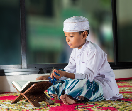 Asian muslim child with smile face reads the holy Quran(the public item of all muslims ).の写真素材