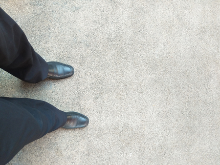 a man with black shoes standing on concrete texture background, ready to startの写真素材